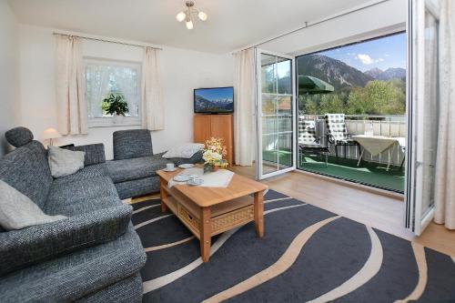 a living room with a couch and a table at Am Badezentrum Ferienwohnungen in Ruhpolding