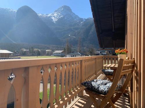 a wooden balcony with a chair and a view of mountains at Iris Apartments in Obertraun