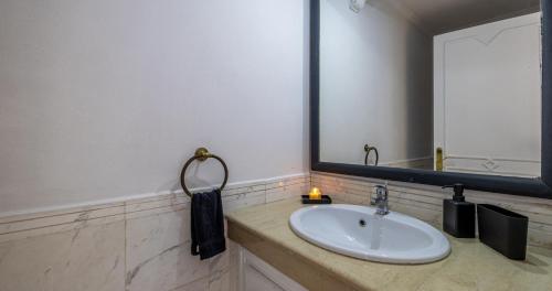 a bathroom with a sink and a large mirror at Charming 2-Bed Oasis Pool View in Marrakech