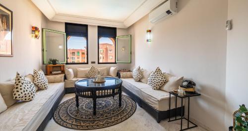 a living room with a couch and a table at Charming 2-Bed Oasis Pool View in Marrakech