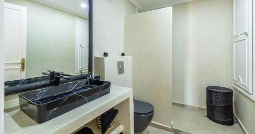 a bathroom with a black sink and a mirror at Charming 2-Bed Oasis Pool View in Marrakesh