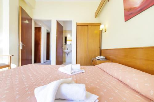 a bedroom with a bed with towels on it at CiTYZen Hotel in Loutraki