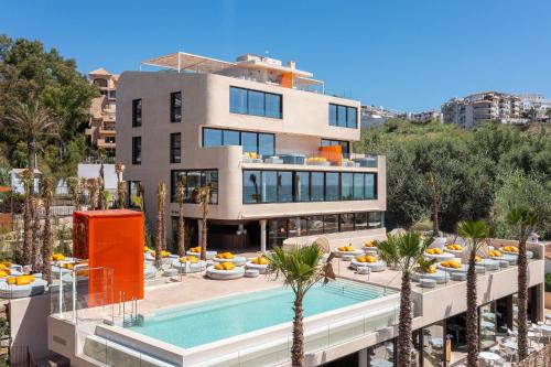a building with a swimming pool next to a resort at Mara's Apartments Higuerón West - Luxurious & Sunny in Fuengirola