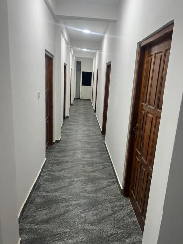 a corridor of a hallway with doors and a carpet at Krishna Bhavan Hotel in Trincomalee