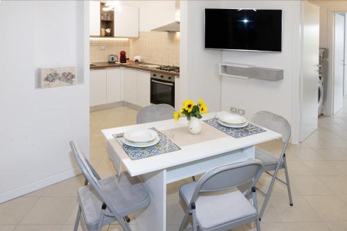 a white kitchen with a white table and chairs at [HEART OF TUSCANY] PINOCCHIO’S in Collodi