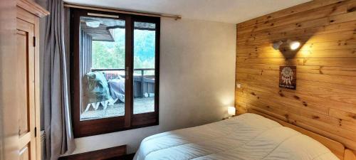 a bedroom with a bed and a window in it at Résidence Le Meale - 3 Pièces pour 6 Personnes 241 in Les Orres