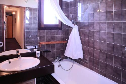 une salle de bain avec un lavabo et une baignoire dans l'établissement Résidence Le Meale - Appartement 6 personnes Résidence Le Méale MAE-6241, aux Orres