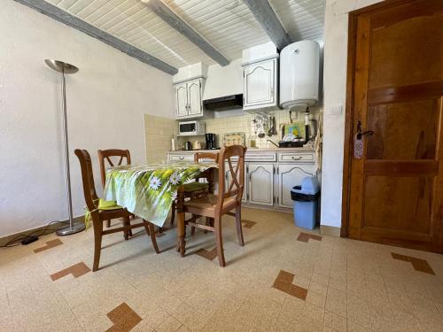 - une cuisine avec une table, des chaises, une table et une porte dans l'établissement T2 pour 4 personnes au cœur de St Martin Vesubie avec parking public devant, à Saint-Martin-Vésubie