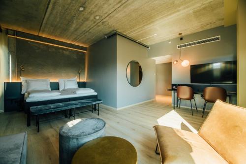 a bedroom with a bed and a couch and a table at Comfort Hotel Porsgrunn in Porsgrunn