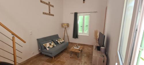 a living room with a couch and a tv at Parenthèse provençale in Graveson