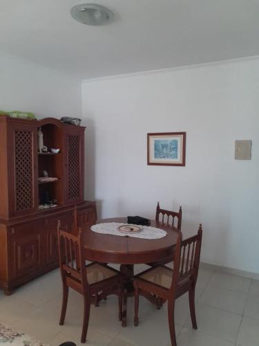 a dining room with a table and two chairs at Apartamento - Jardim Marina in Mongaguá