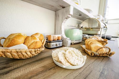 Un grupo de panes y pasteles en cestas sobre un mostrador. en Étoiles Luxury guest house Resort, en Palmi