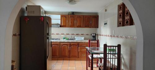 a kitchen with wooden cabinets and a black refrigerator at Disfruta San Antonio en Cali in Cali