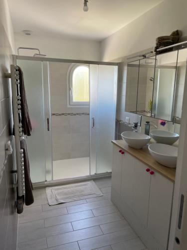 a white bathroom with two sinks and a shower at Grande maison 132m2 avec jardin et piscine à 15min de la plage in La Crau