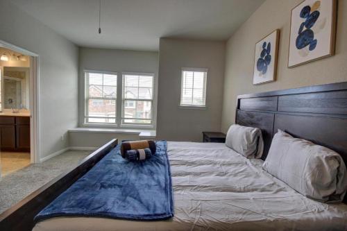 a bedroom with a large bed with a blue blanket on it at Roseberg-Suglarland 3-BR - Extended Stay 30 days in Rosenberg