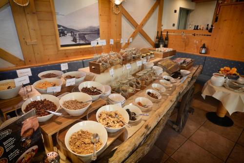 a buffet with bowls of food on a table at Hotel Interalpen in Valdidentro