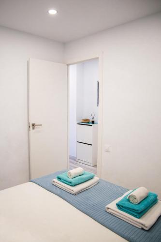 a white bedroom with two towels on a bed at DANICO PLAYA HONDA 218 in Playa de las Americas