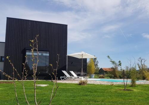 um edifício negro com piscina e relvado em Der Schwarzbau - Luxus Ferienhaus em Runding