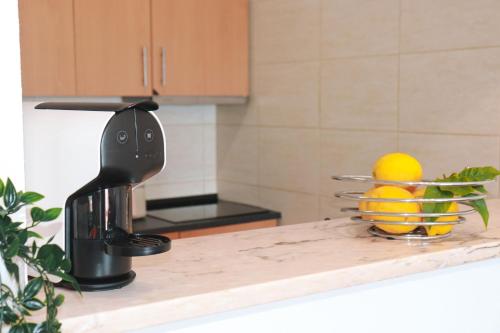 a kitchen counter with a juicer and an orange on it at Casa Amar- Vista panorâmica in Luz
