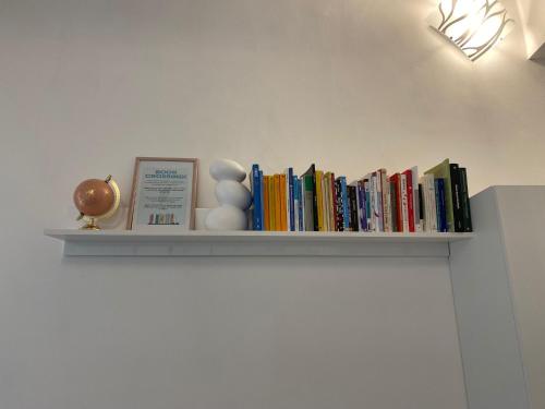 a shelf with books and toys on a wall at Brignole Home in Genova