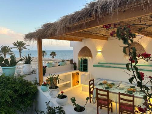 a patio with a table and chairs and the ocean at Dar El Mahdia by Daldoul in Mahdia