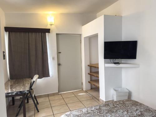 a bedroom with a bed and a desk and a television at Eco Bay Hotel in Bahía Kino