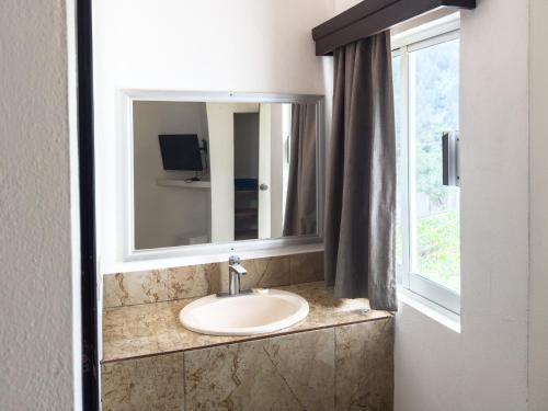 a bathroom sink with a mirror and a window at Eco Bay Hotel in Bahía Kino