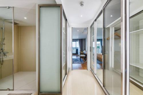 a hallway with glass doors leading to a bedroom at Iconic skyline, Big apartment, Great location in Bangkok