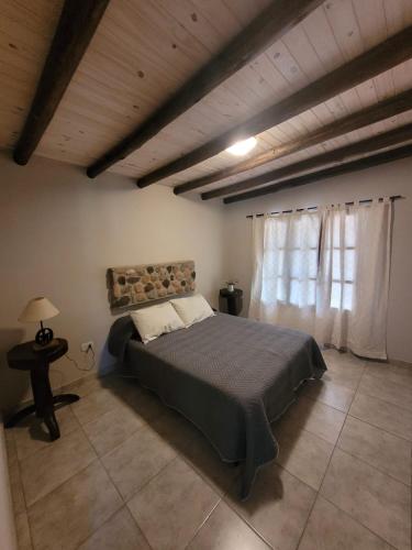 um quarto com uma cama grande e uma janela em Casa de Campo Don Valentin em Tunuyán