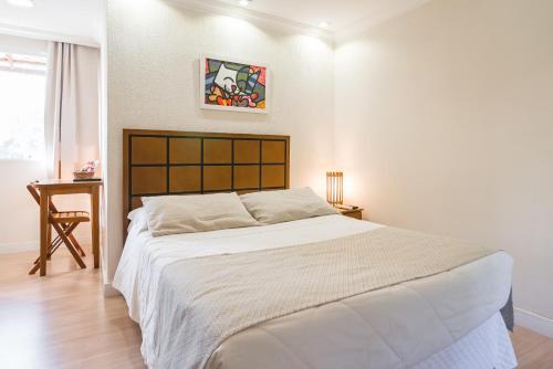 a bedroom with a large bed and a table at Hotel Serra Everest in Nova Friburgo