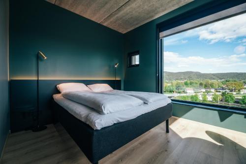 a bedroom with a bed and a large window at Comfort Hotel Porsgrunn in Porsgrunn