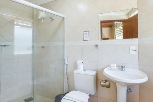 a bathroom with a toilet and a sink and a shower at Hotel Serra Everest in Nova Friburgo