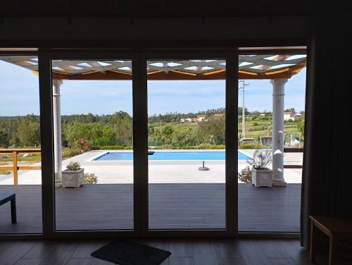 una puerta corredera de cristal con vistas a la piscina en Quinta da Fonte, en Torneira