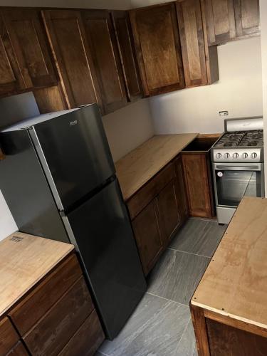 a kitchen with a black refrigerator and wooden cabinets at Departamento Tulipán in San Felipe