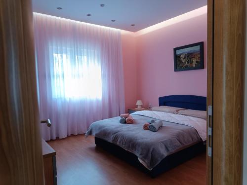 1 dormitorio con 1 cama y una ventana con paredes rosas en Kuća za odmor DESA, 