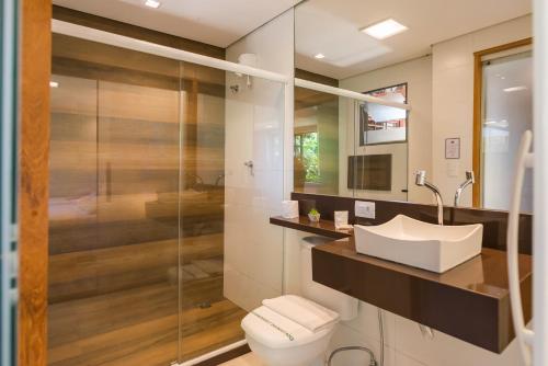 a bathroom with a toilet and a sink and a shower at Hotel Serra Everest in Nova Friburgo