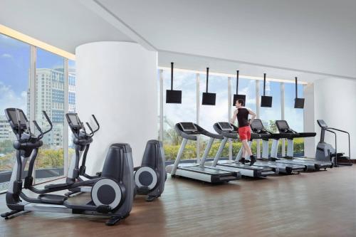 a woman standing on a treadmill in a gym at JW Marriott Hotel Surabaya in Surabaya