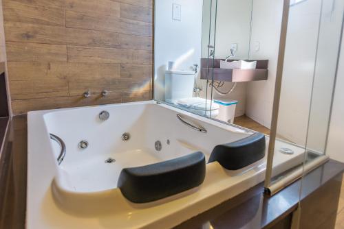 a bath tub with two black seats in a bathroom at Hotel Serra Everest in Nova Friburgo