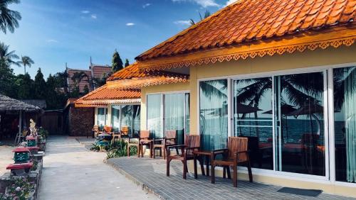 象島的住宿－閣昌島度假酒店，一座配有桌椅的庭院和一座建筑
