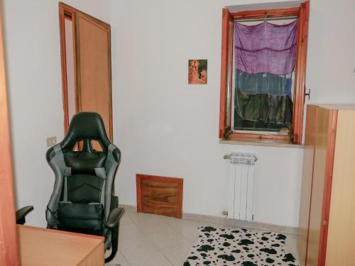 a green chair in a room with a window at Le Magnolie Paliano appartamento 120 mq in Paliano