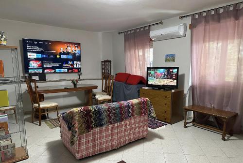 een woonkamer met een bank en een flatscreen-tv bij Alloggio turistico appartamento casa Le Magnolie presso Magicland e Magicsplash in Paliano