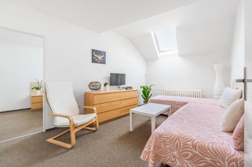 a bedroom with a bed and a chair and a tv at Apartmány Rozárka Turnov in Turnov