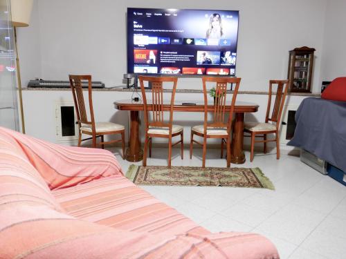 a living room with a table and chairs and a tv at Le Magnolie Paliano appartamento 120 mq in Paliano
