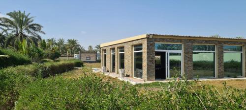 una casa con ventanas de cristal y un edificio en Aram luxurious five bedroom villa with pools & fountains, en Sohar
