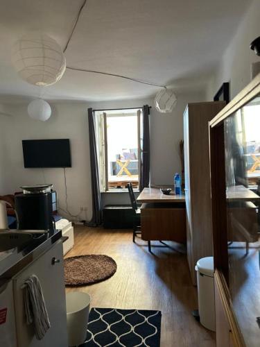 a room with a kitchen and a desk with a window at Trier City Center Apartments Altstadt in Trier