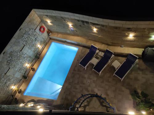 a swimming pool with blue water in a building at Il Hnejja Farmhouse in Mqabba