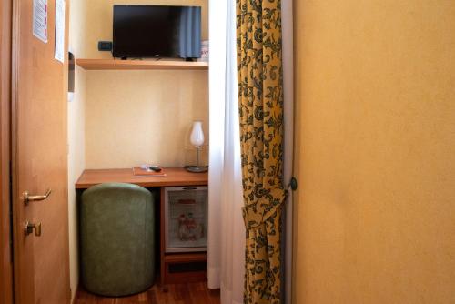 a room with a desk and a door with a green chair at SIRIOHotel in Dormelletto