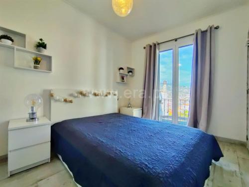 a bedroom with a blue bed and a large window at Lydia's Place in Funchal