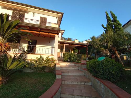 a house with a staircase leading to the front yard at Villa Framaca in Furnari