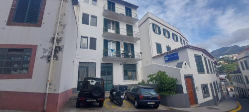 a white building with a motorcycle parked in front of it at Lydia's Place in Funchal